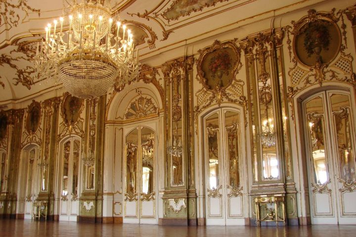 Ornate ballroom with chandeliers, mirrored walls, and intricate ceiling designs.
