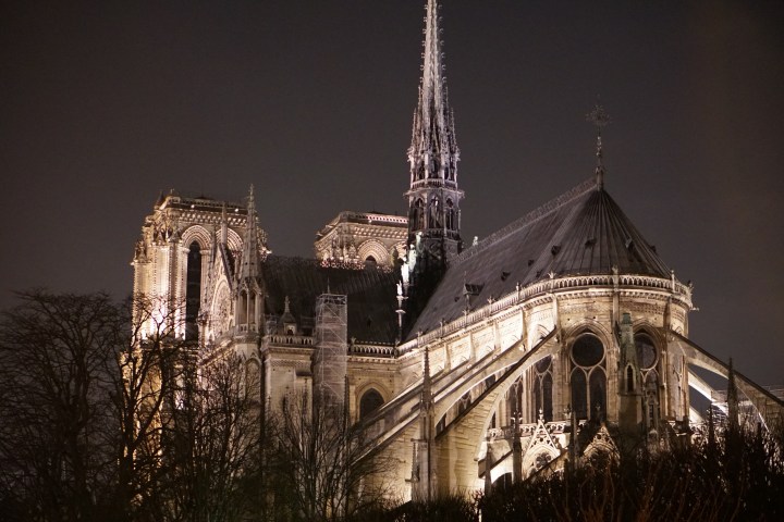 Illuminated gothic cathedral at night with dark sky background.