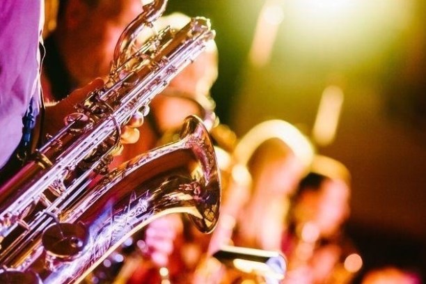Close-up of saxophone players on stage with bright lights.