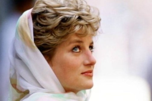 Woman with short hair, wearing a light headscarf, looking upward.