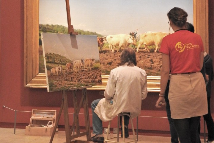 Artist painting a copy of a large artwork depicting cows in a museum, with onlookers watching.