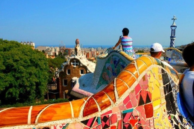 People admire colorful mosaic terrace with city and sea view.