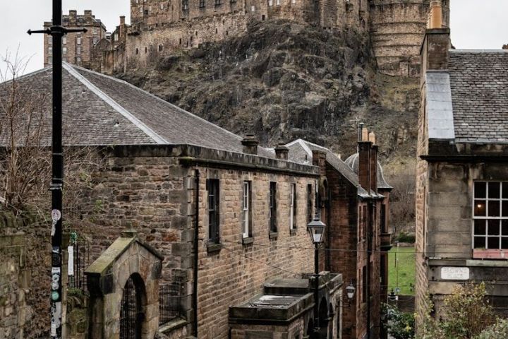 Stone stairway leading to a historic castle on a cloudy day.