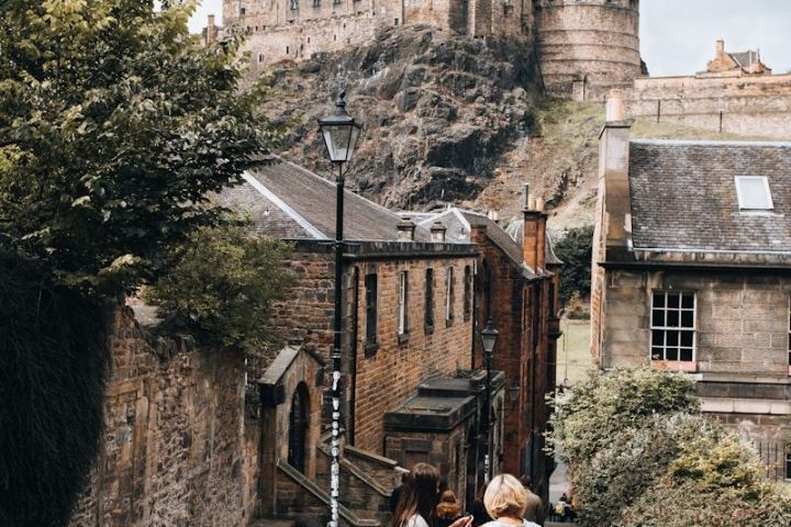 Two women stand on a staircase, looking at a historic castle on a hill.