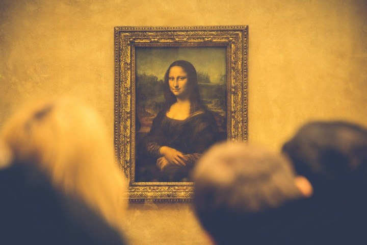 Crowd viewing the Mona Lisa painting in a museum.