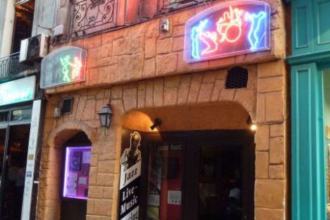 Facade with neon jazz club signs, arches, and a sign for live music and dancing.