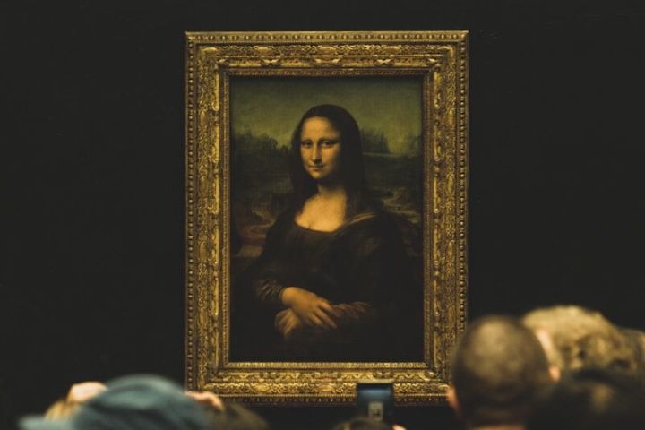 People viewing the Mona Lisa painting in a museum.