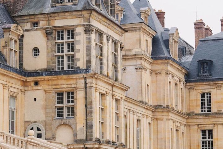 Historic stone building with ornate architecture and steep roofs.