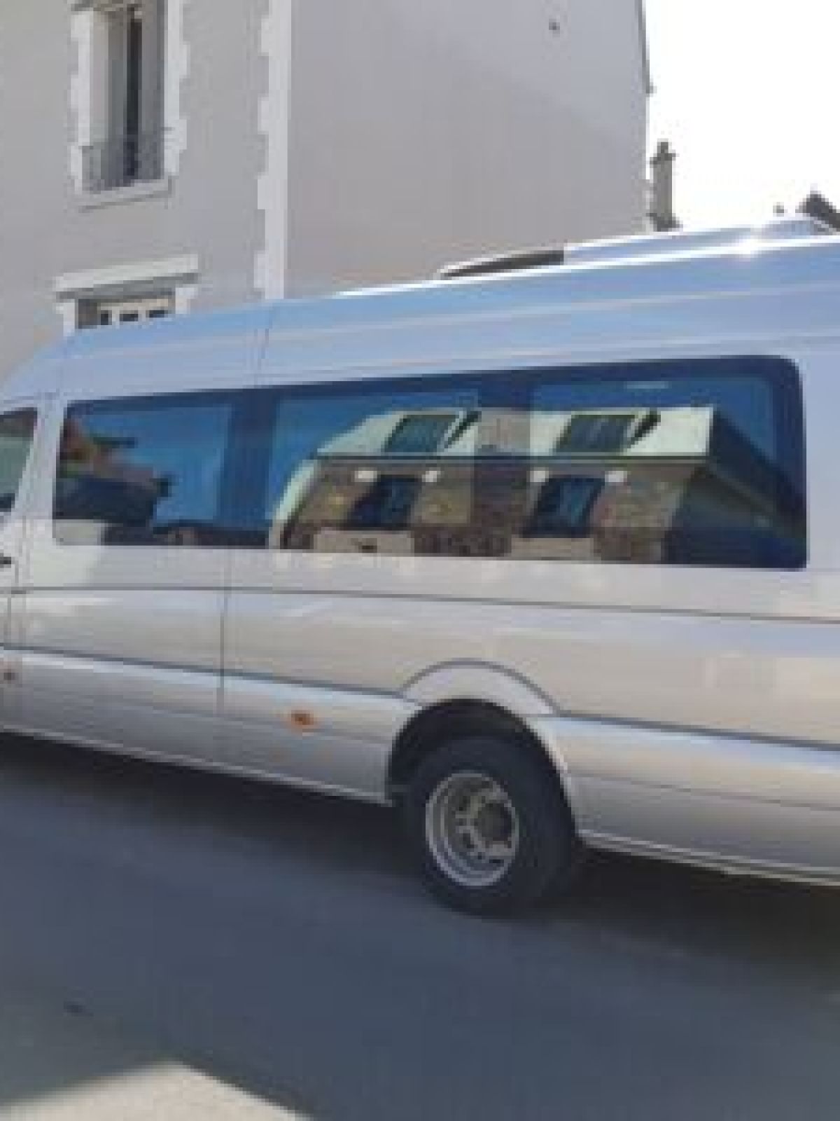 Silver minibus parked on a residential street.