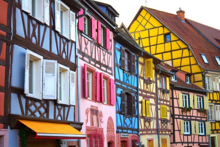 Colorful half-timbered buildings with multicolored shutters in a European architectural style.