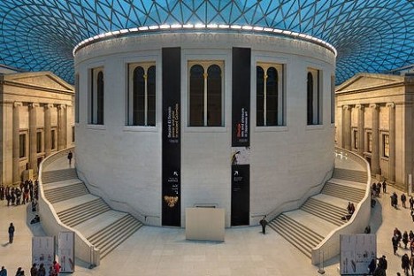 Interior of a museum with a central rotunda, staircases, and a glass roof.