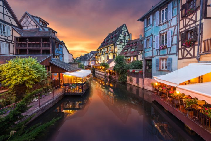 Charming canal town with colorful half-timbered houses at sunset.